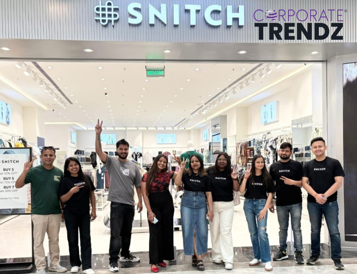 A group of people, likely including Siddharth Dungarwal (Founder and CEO of Snitch), celebrating in a modern retail store setting, with a subtle indication of fashion apparel.