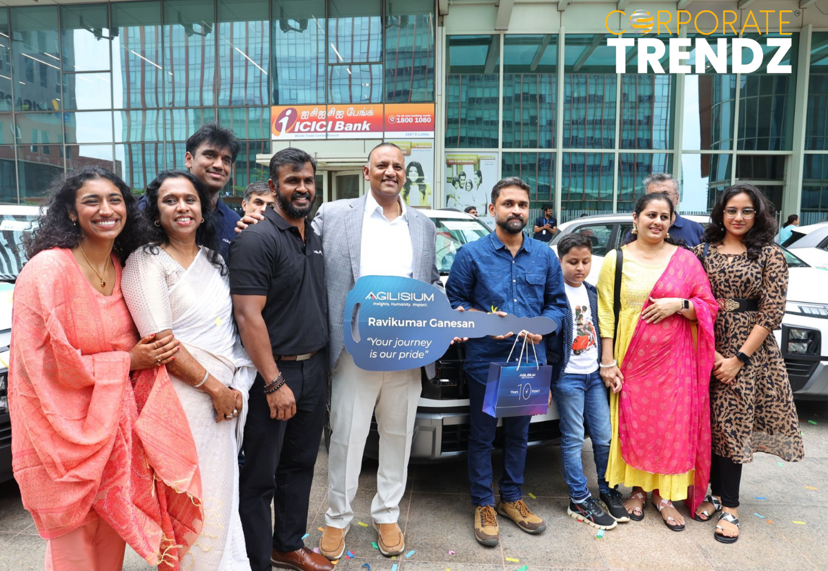 Agilisium founder Raj Babu standing with 25 new SUVs, surrounded by excited employees and their families, celebrating the gifting of vehicles.