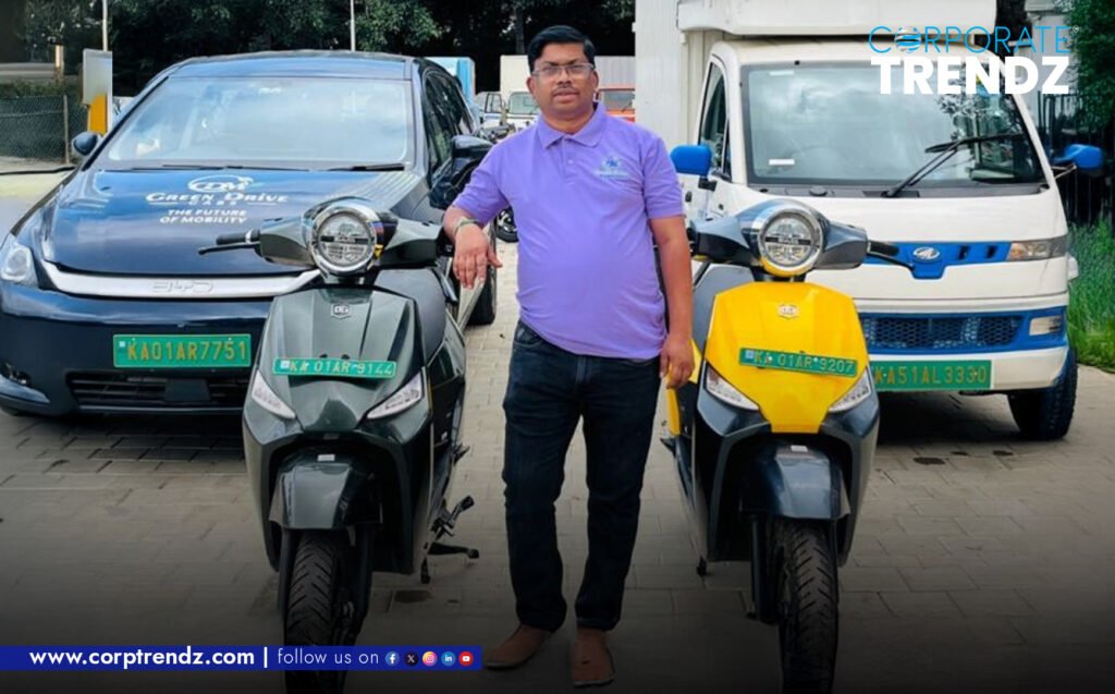 Hari Krishna, founder of Green Drive Mobility, standing proudly with a fleet of Green Drive electric two-wheelers in an urban setting.